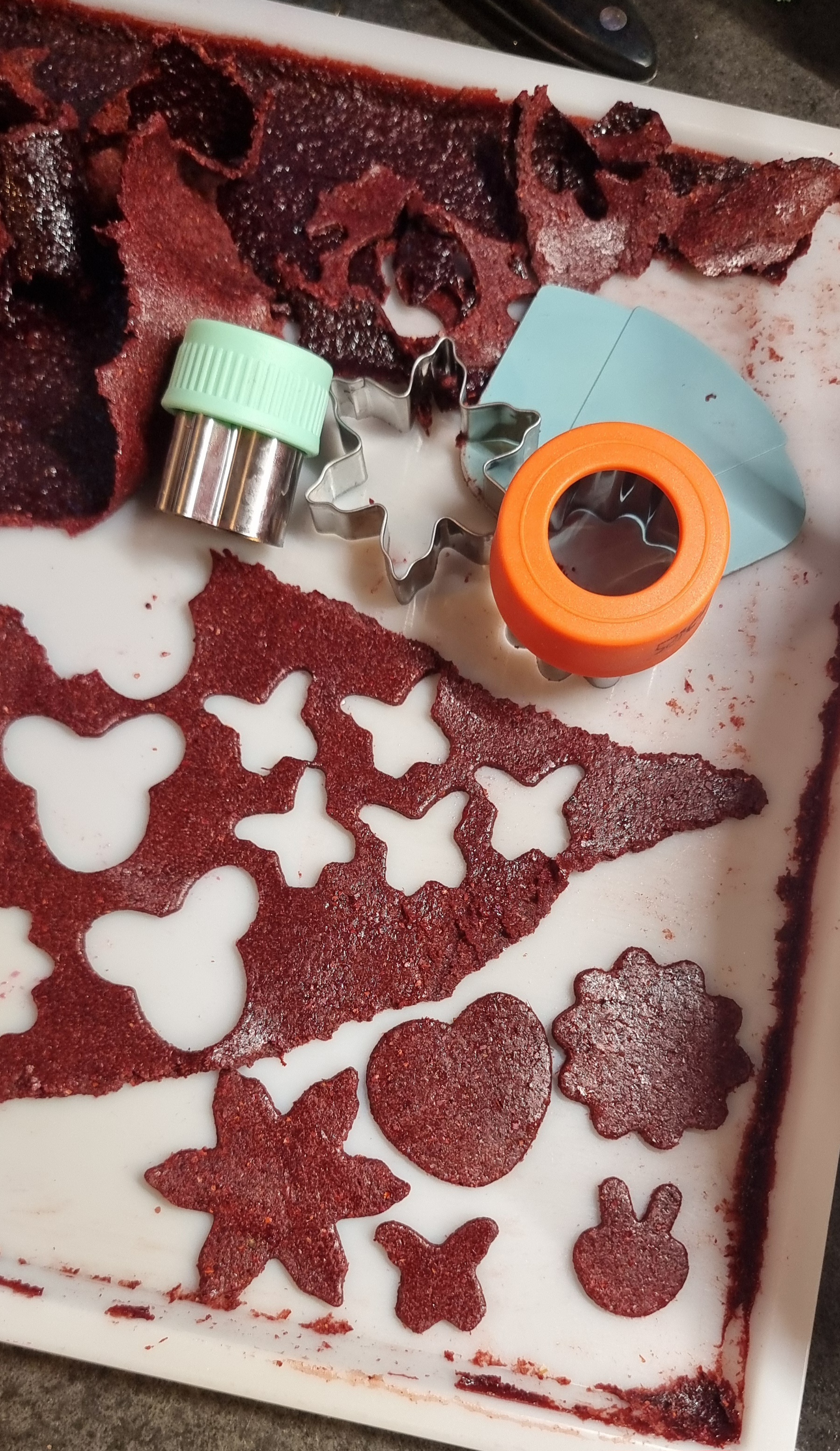 Ausgestochene Formen aus Fruchtleder – kleine Herzen, Sterne und Schmetterlinge, hergestellt aus getrocknetem Fruchtpüree. Ein liebevoller, gesunder Snack für Kinder.